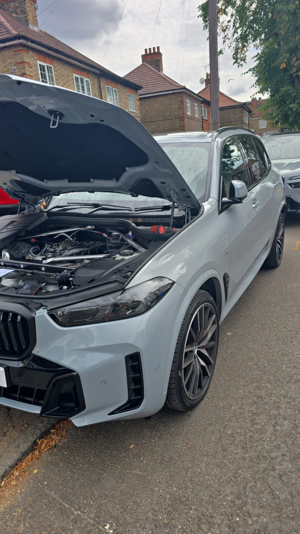 BMW X5 M Sport with the bonnet raised during an on-site ECU tuning session